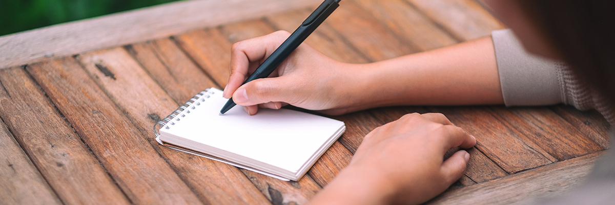 Woman writing on a notepad
