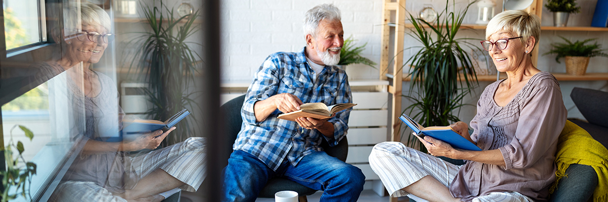 Senior couple reading books in living area