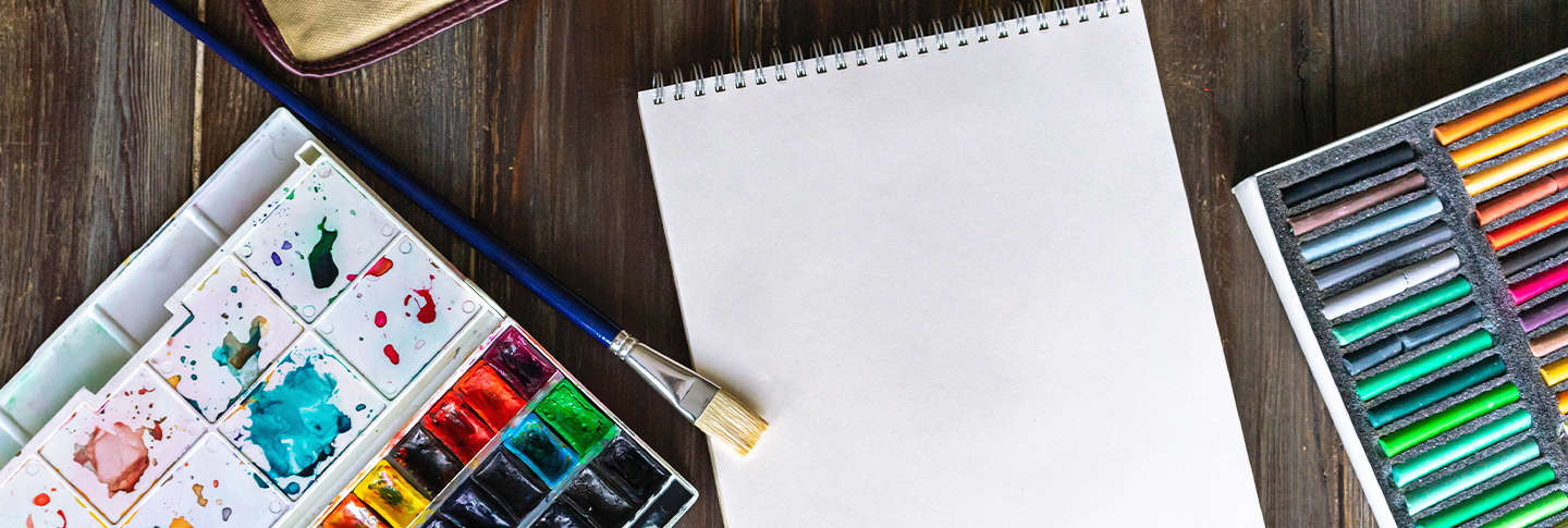 Paint brush and watercolors on blank canvas