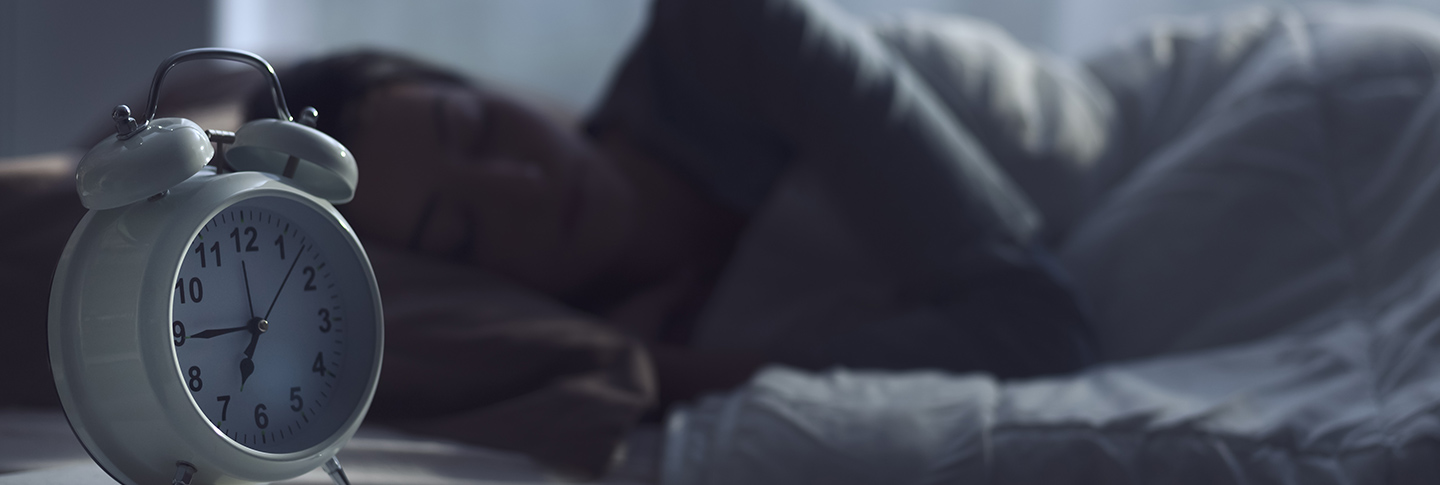 Woman sleeping next to alarm clock